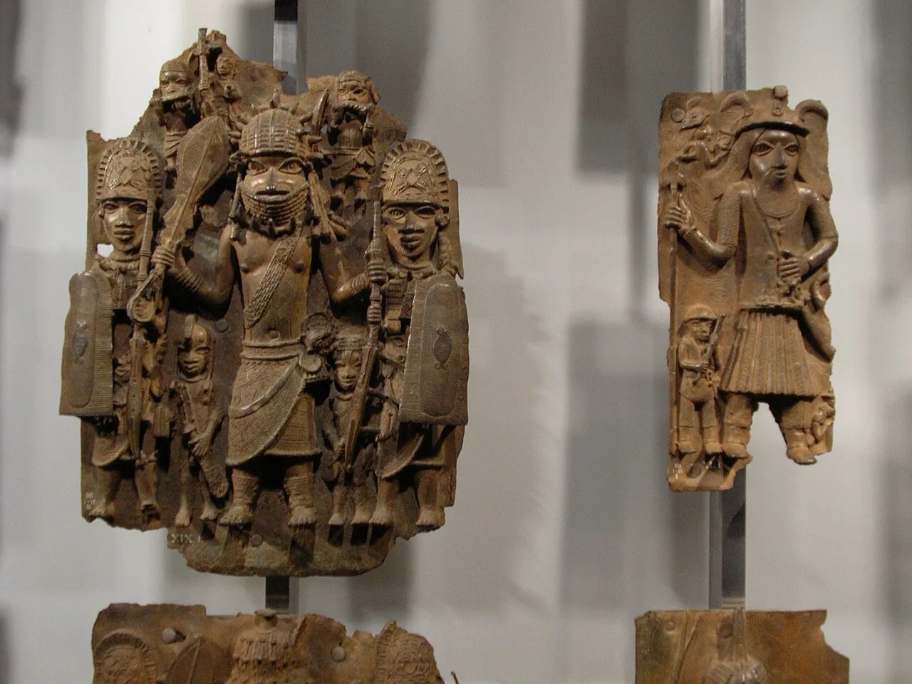 A selection of Benin Bronze plaques and heads on display, showing the intricate brass casting work of the Kingdom of Benin, Nigeria, 13th to 19th century