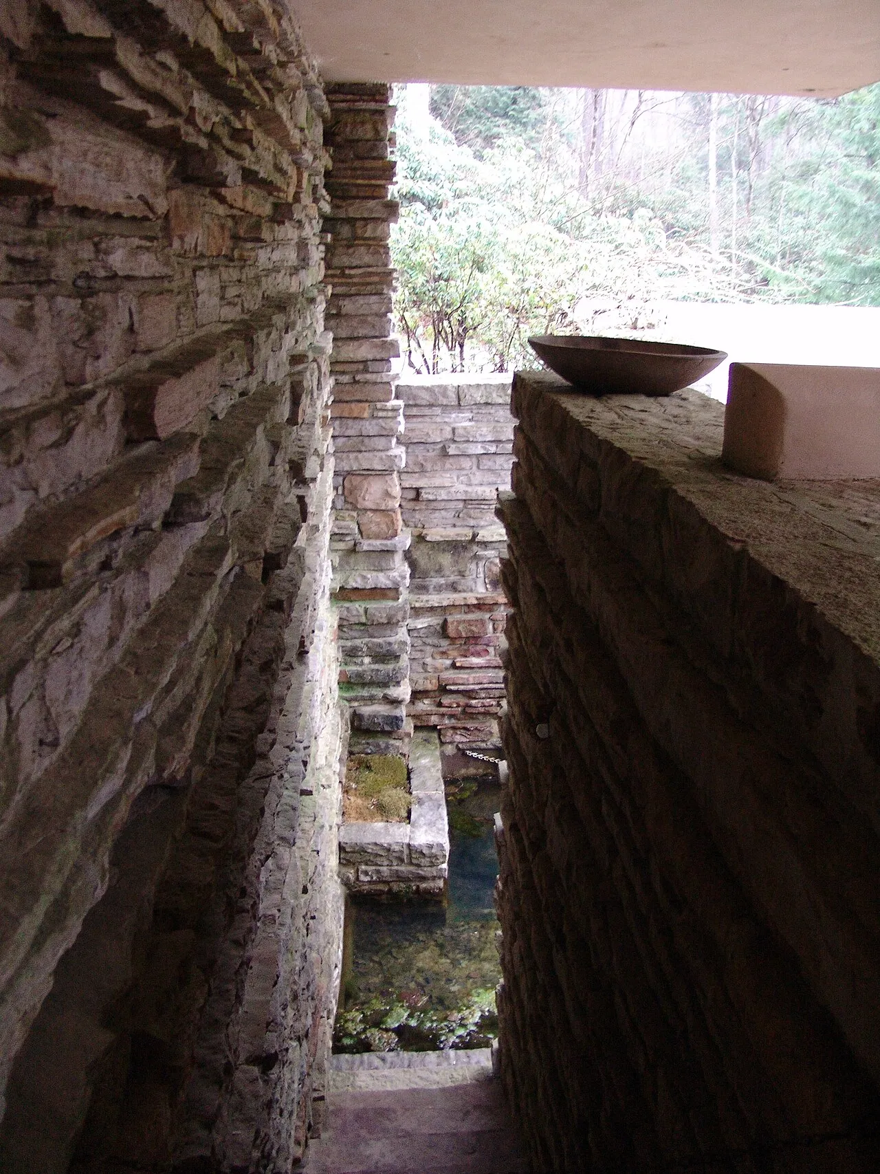 Fallingwater (1935) by Frank Lloyd Wright, showing the famous cantilevered concrete terraces of the house built over a waterfall in Bear Run, Pennsylvania, surrounded by autumn forest