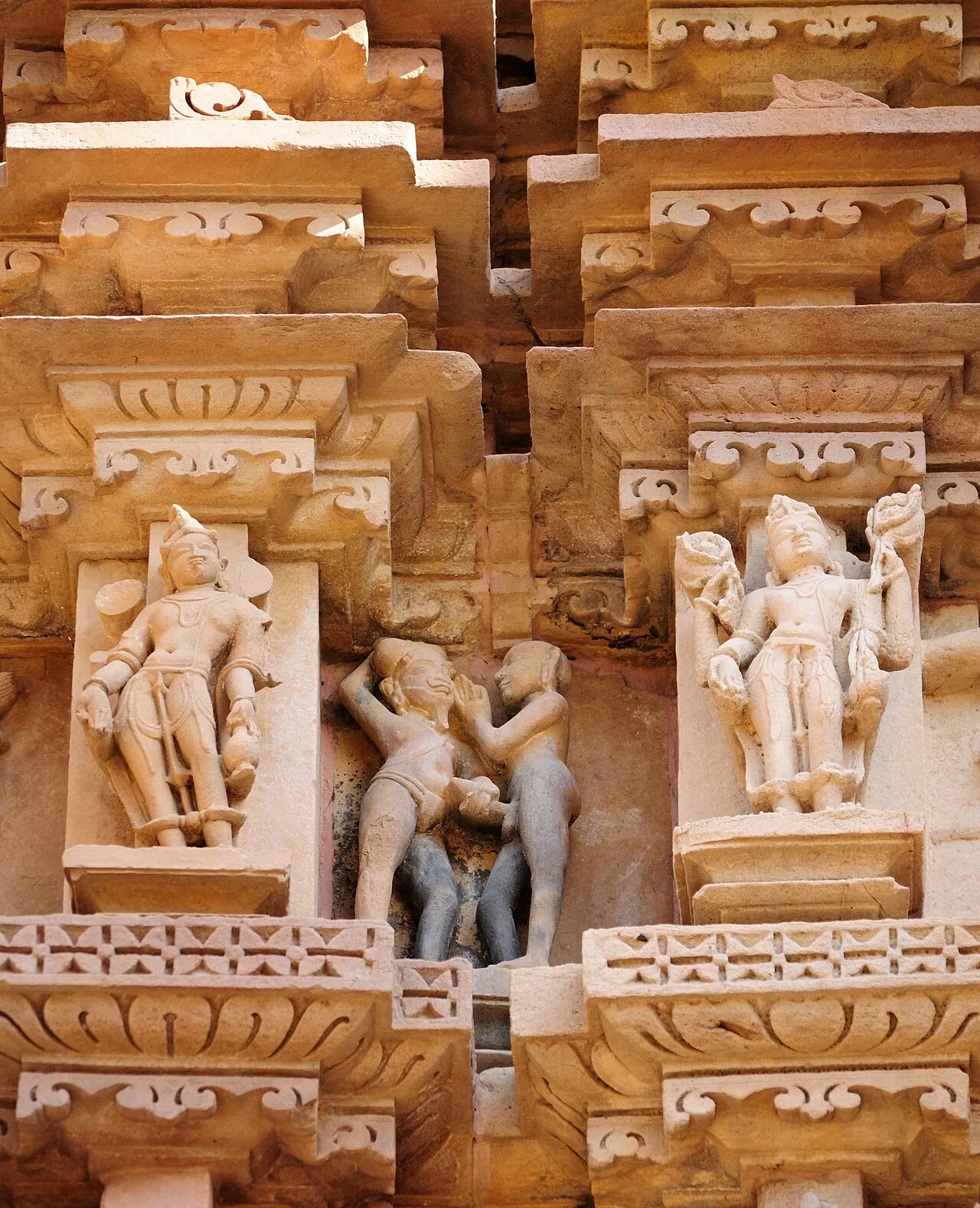The Kandariya Mahadeva temple at Khajuraho (c.1030 CE) showing the soaring shikhara tower and elaborate exterior sculptural program covering the entire surface with carved figures of deities, celestial beings, and human life