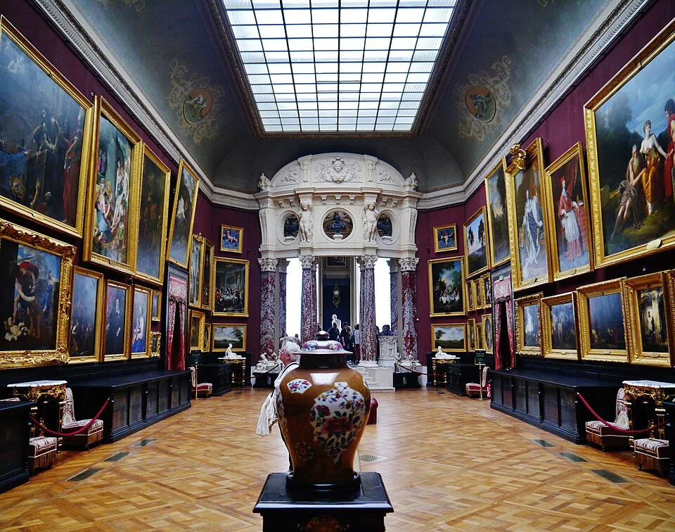 Picture Gallery of Chantilly Palace, France, showing paintings hung floor to ceiling in a historic gallery setting