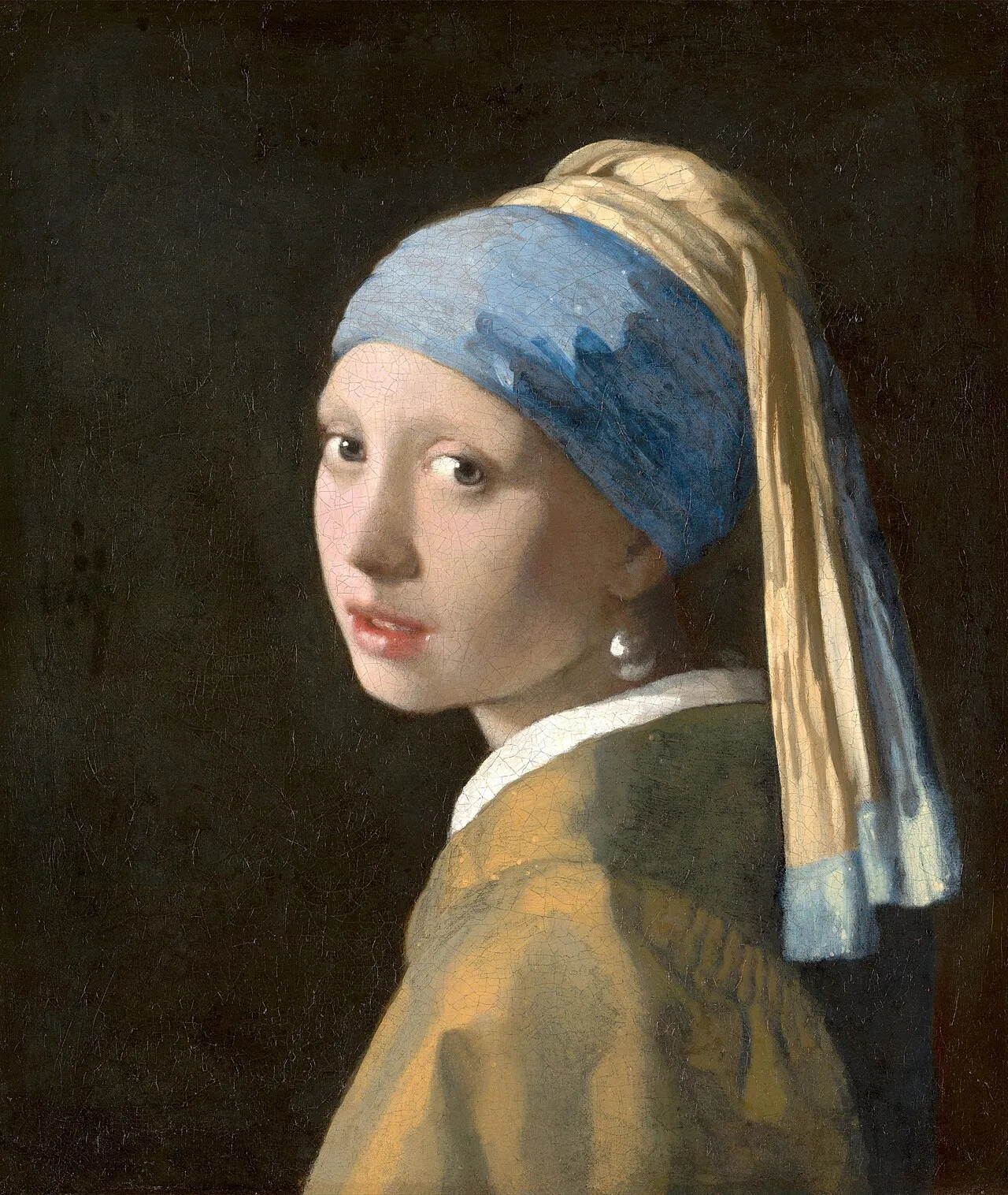 Girl with a Pearl Earring (c.1665) by Johannes Vermeer, oil on canvas, showing a young woman in a blue and yellow headscarf turning to look over her shoulder at the viewer against a dark background, with a large pearl earring catching the light