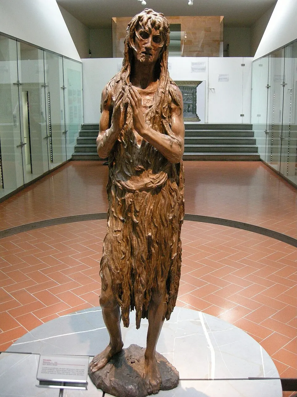 A depiction of Mary Magdalene with long flowing red hair covering her body, a visual attribute identifying her as both the repentant sinner and the holy anointer, hair in its color, length, and style encoding spiritual and moral characteristics