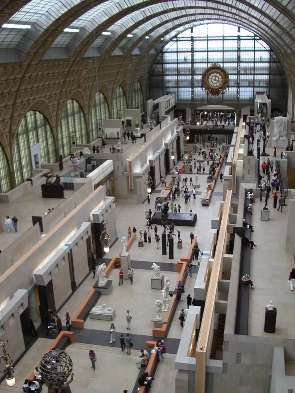 The interior of the Musee d'Orsay in Paris showing its grand architecture with arched ceiling and artworks displayed along the main hall