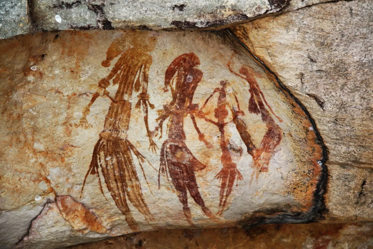 Bradshaw rock paintings (Gwion Gwion) in the Kimberley region of Western Australia, showing elongated human figures in dynamic poses, estimated at over 17,000 years old