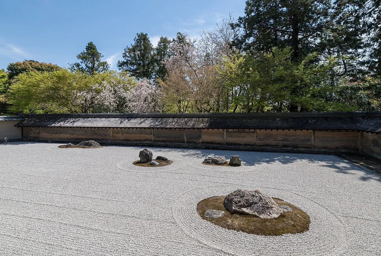 The Ryoan-ji rock garden in Kyoto, Japan, a classic example of kare-sansui (dry landscape garden) featuring fifteen rocks arranged in raked white gravel