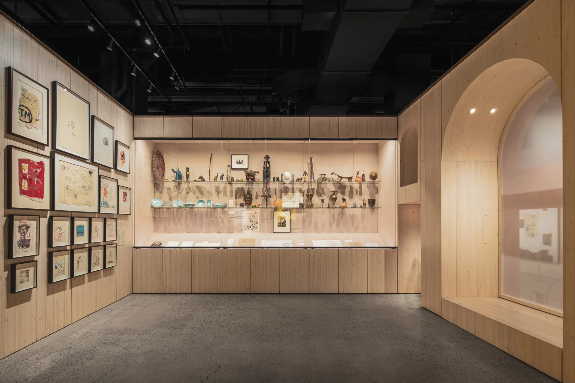 Exhibition view of Jean-Michel Basquiat works showing his distinctive style of crowns, skulls, and text
