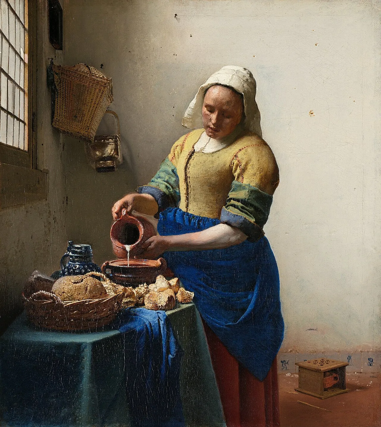 The Milkmaid (c.1658) by Johannes Vermeer showing a kitchen maid pouring milk from a jug in a simply furnished room, illuminated by cool window light from the left that models every surface and texture with extraordinary precision