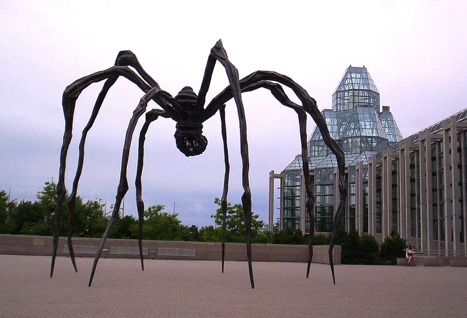 Louise Bourgeois, Maman (1999). Bronze, stainless steel, and marble. Giant spider sculpture with egg sac cage installed at the National Gallery of Canada in Ottawa, photographed against a clear sky.