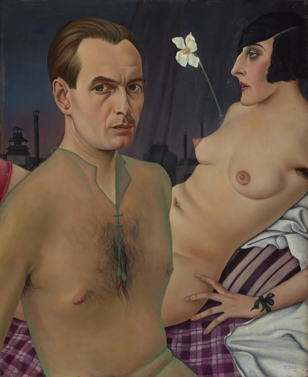 Christian Schad, Self-Portrait, 1927. The artist poses nude with a woman who has a scarred face, a model of a stag, and a green veil, in a precisely rendered but deeply unsettling scene.
