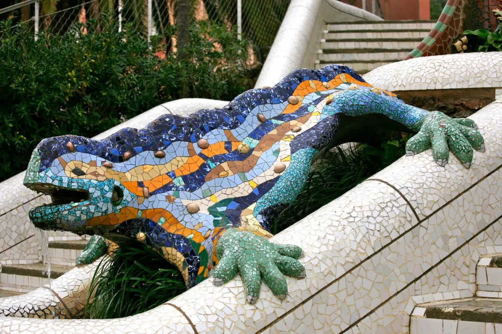 The salamander or dragon fountain at Park Guell, Barcelona, covered in Gaudi's trencadis mosaic of broken ceramic tile in blue, green, and yellow fragments
