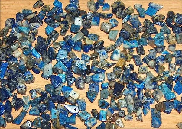 A raw piece of lapis lazuli stone showing deep blue coloration with golden pyrite flecks, the mineral source of natural ultramarine pigment