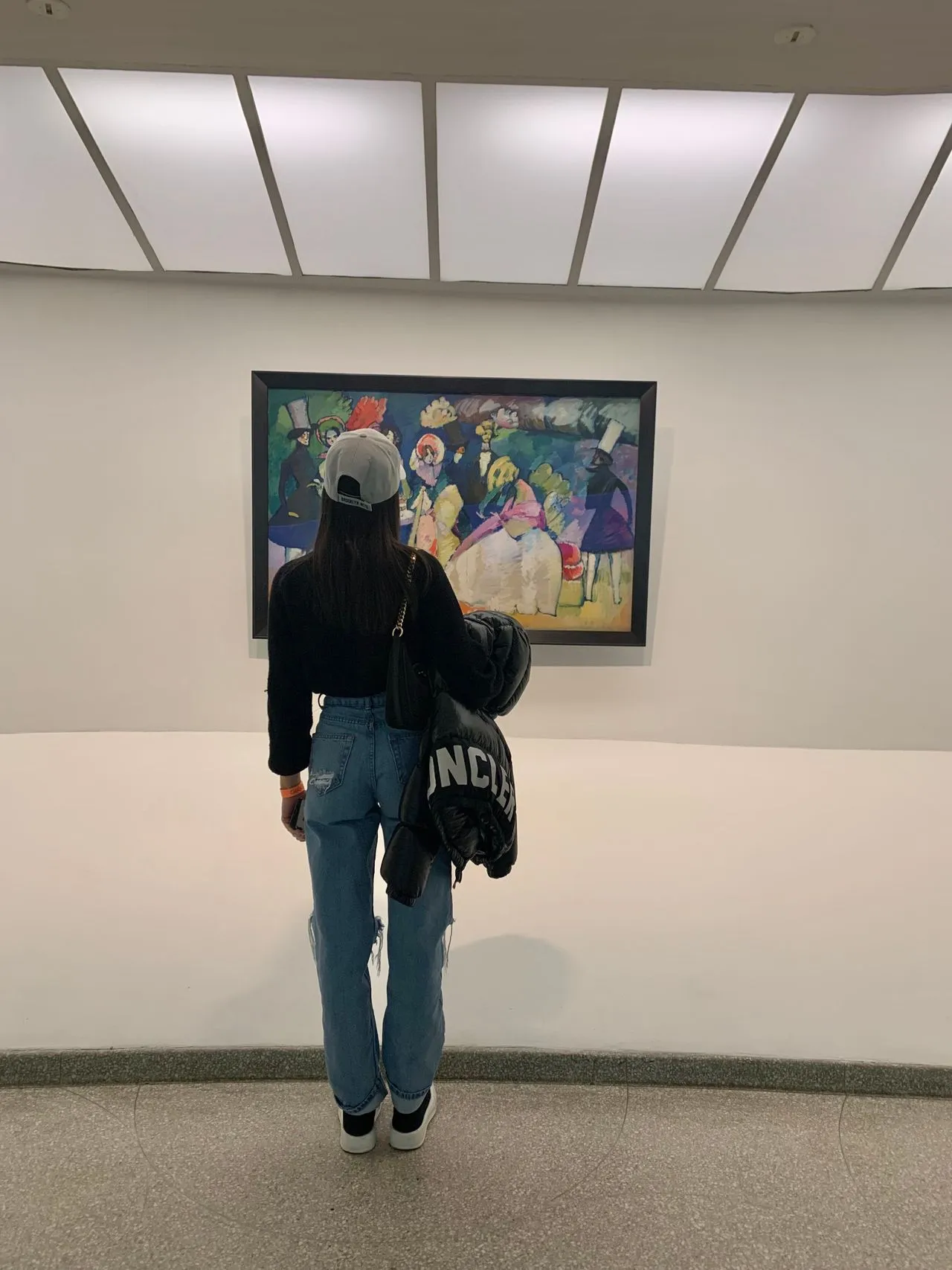 A Woman Admiring a Painting at an art gallery