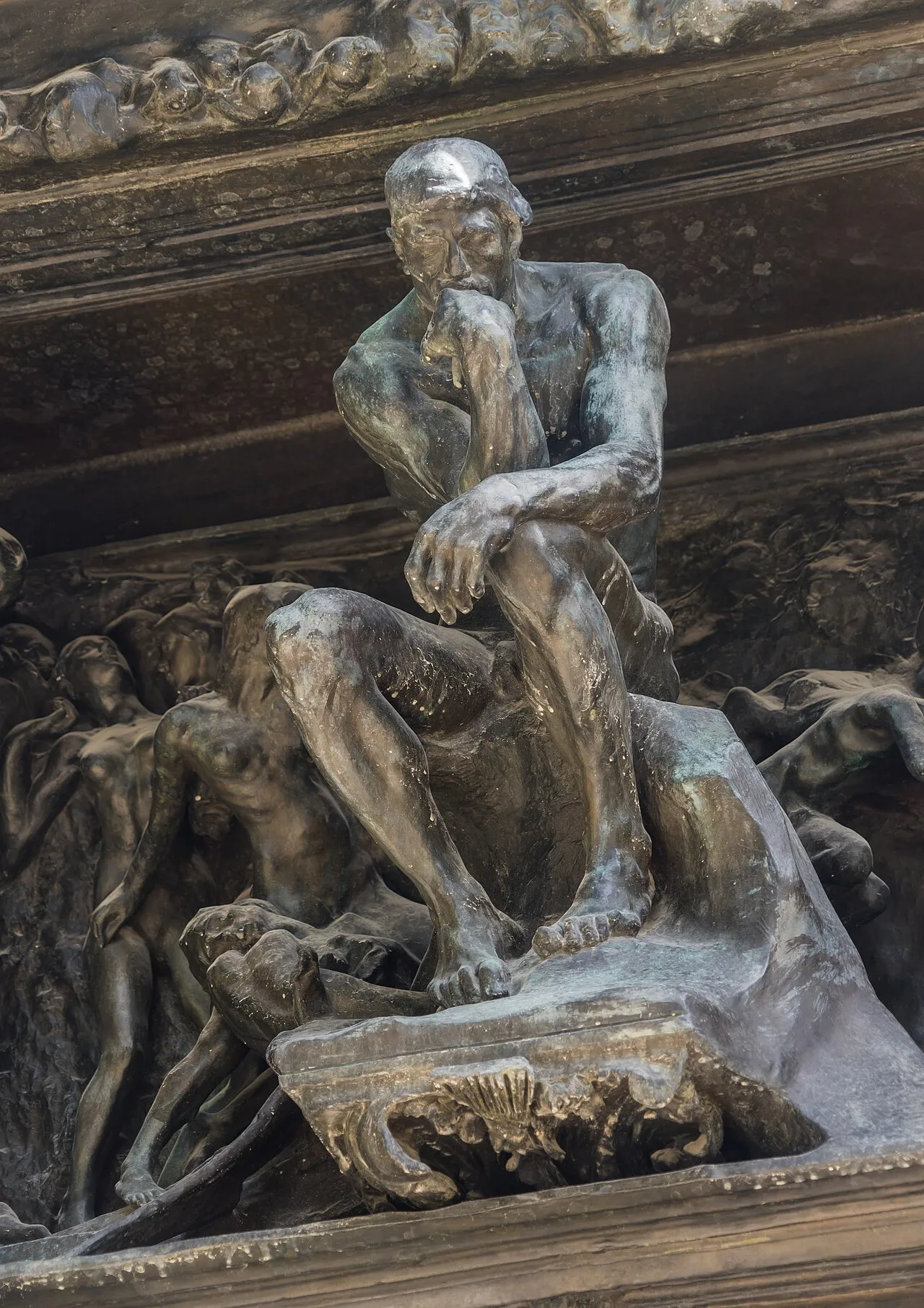 The Gates of Hell by Auguste Rodin showing the monumental bronze doors covered with writhing figures from Dante's Inferno, with The Thinker visible in the central tympanum above the doors