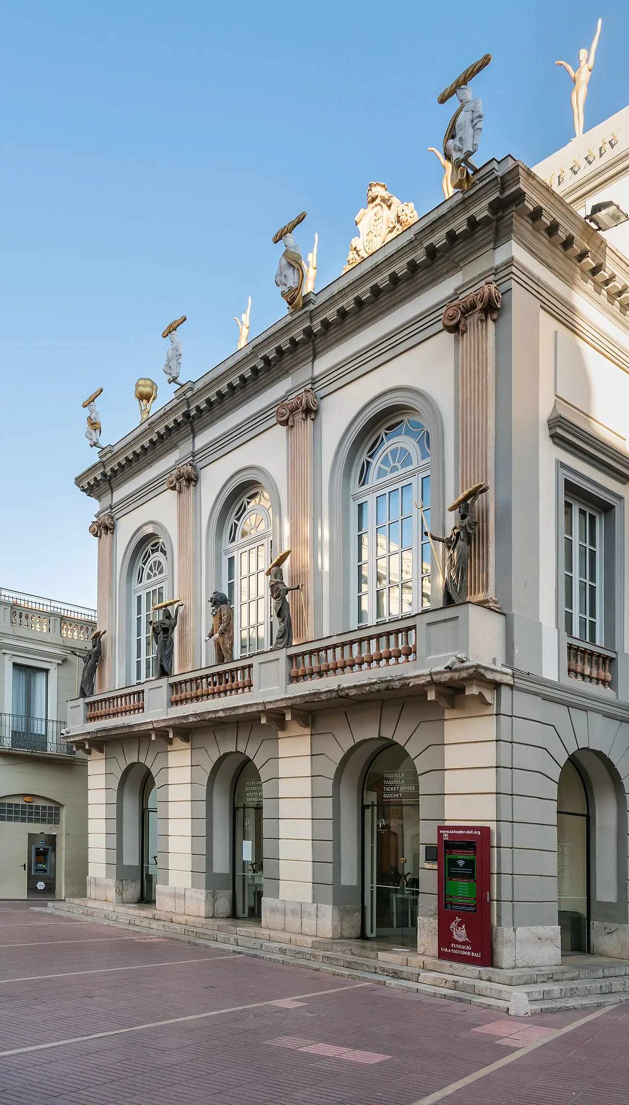 The Teatro-Museo Dalí in Figueres, Catalonia, showing the building's distinctive facade with giant egg sculptures on the roofline and a transparent geodesic dome over the central tower