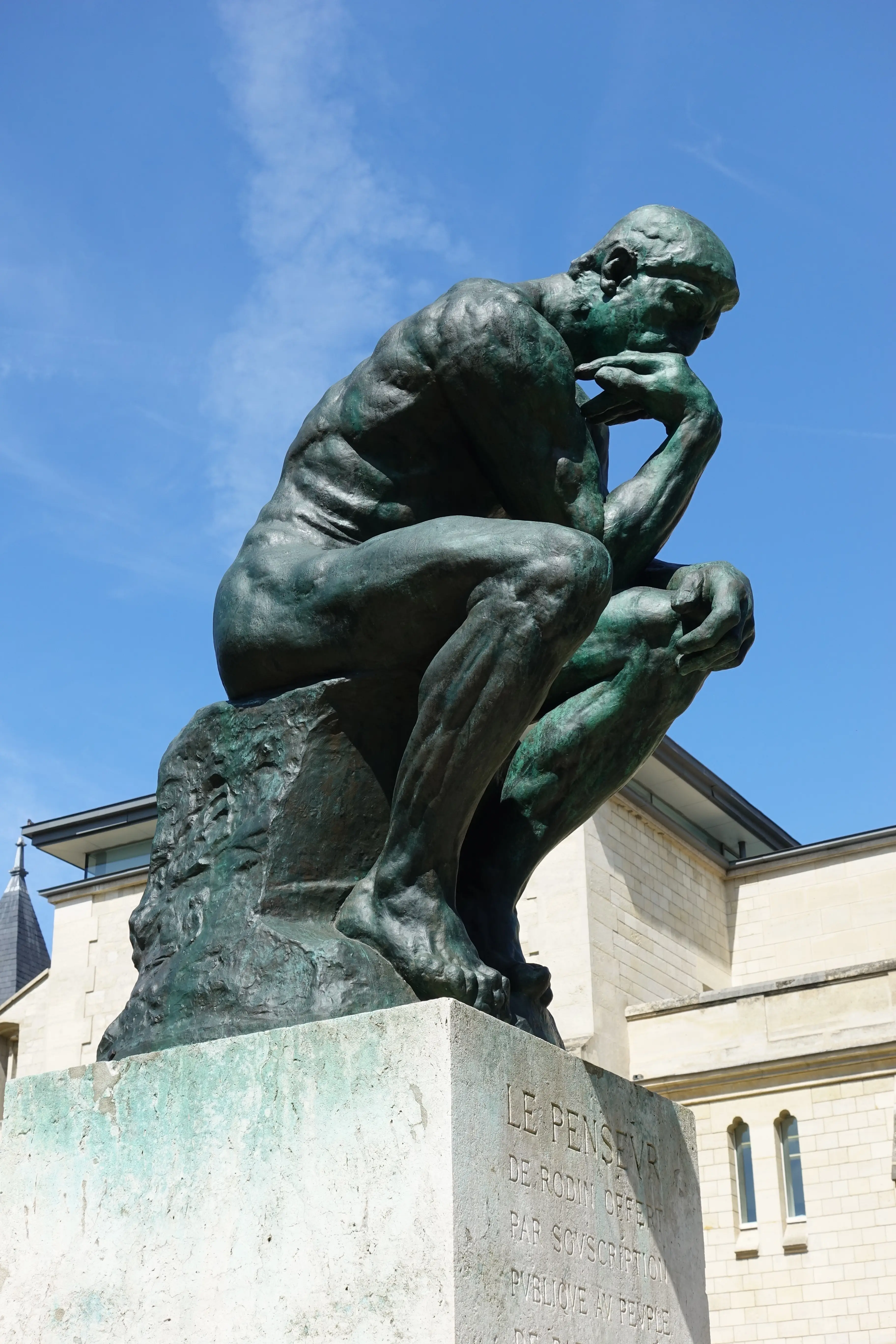 The Thinker by Auguste Rodin, the iconic bronze sculpture of a seated figure with chin resting on hand in contemplation