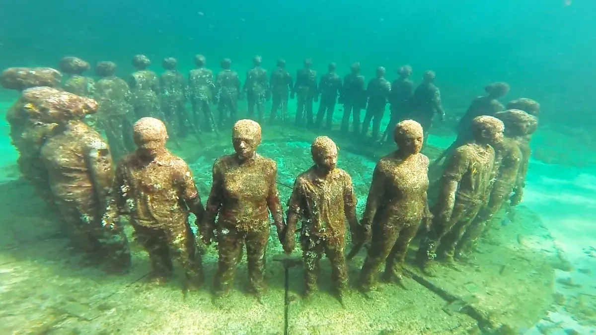 The Molinere Underwater Sculpture Park in Grenada showing submerged concrete figures that have been colonized by coral and marine life