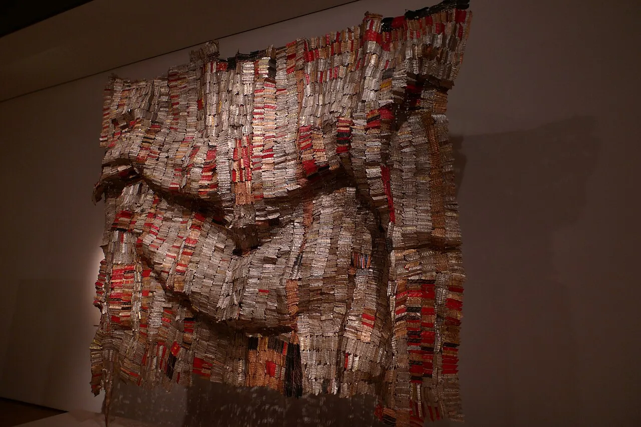 Man's Cloth by El Anatsui, a large-scale work made from thousands of flattened aluminium bottle caps and copper wire stitched together to resemble West African kente cloth, bridging textile tradition and contemporary sculpture