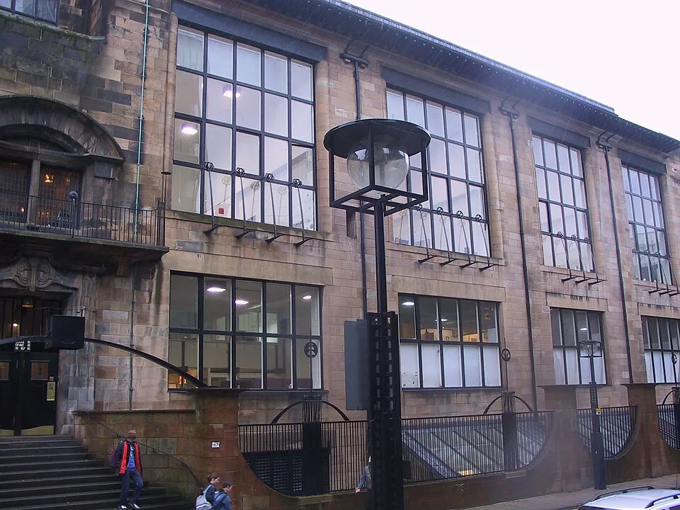 Charles Rennie Mackintosh, Glasgow School of Art building, 1899-1909. A stone building with large studio windows, ironwork details, and a distinctive Scottish baronial-meets-modern aesthetic.