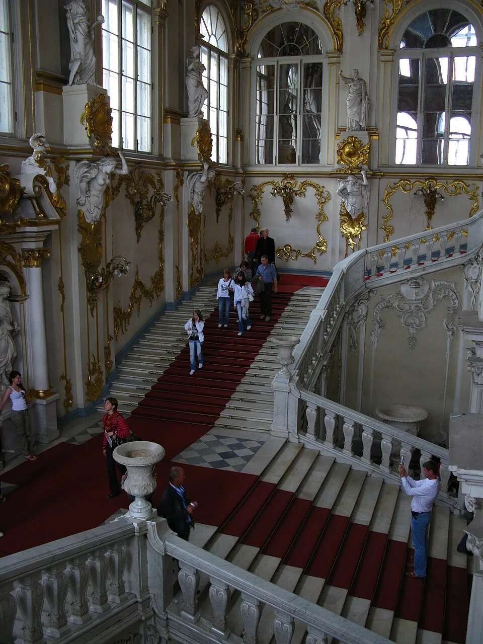The Jordan Staircase in the Winter Palace, a grand white marble staircase with gilded decorations and a ceiling painting, leading up to the state rooms