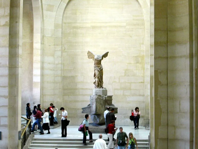 Winged Victory of Samothrace, a headless marble statue of Nike standing on the prow of a warship with wind-blown drapery.