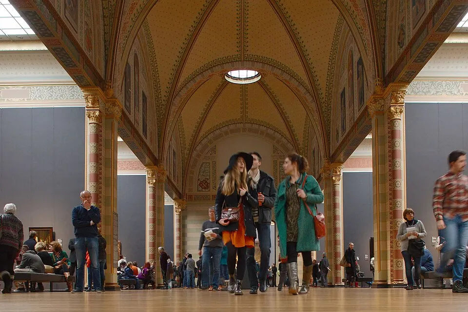 The Gallery of Honour at the Rijksmuseum, a long vaulted hallway with paintings on both walls and skylights illuminating the space.