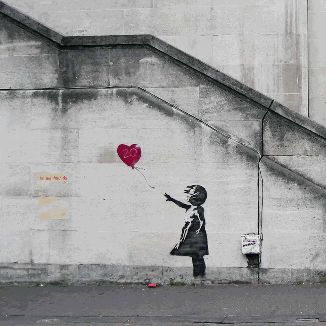 Banksy's Girl with Balloon stencil on a wall in London showing a small girl reaching for a red heart-shaped balloon floating away