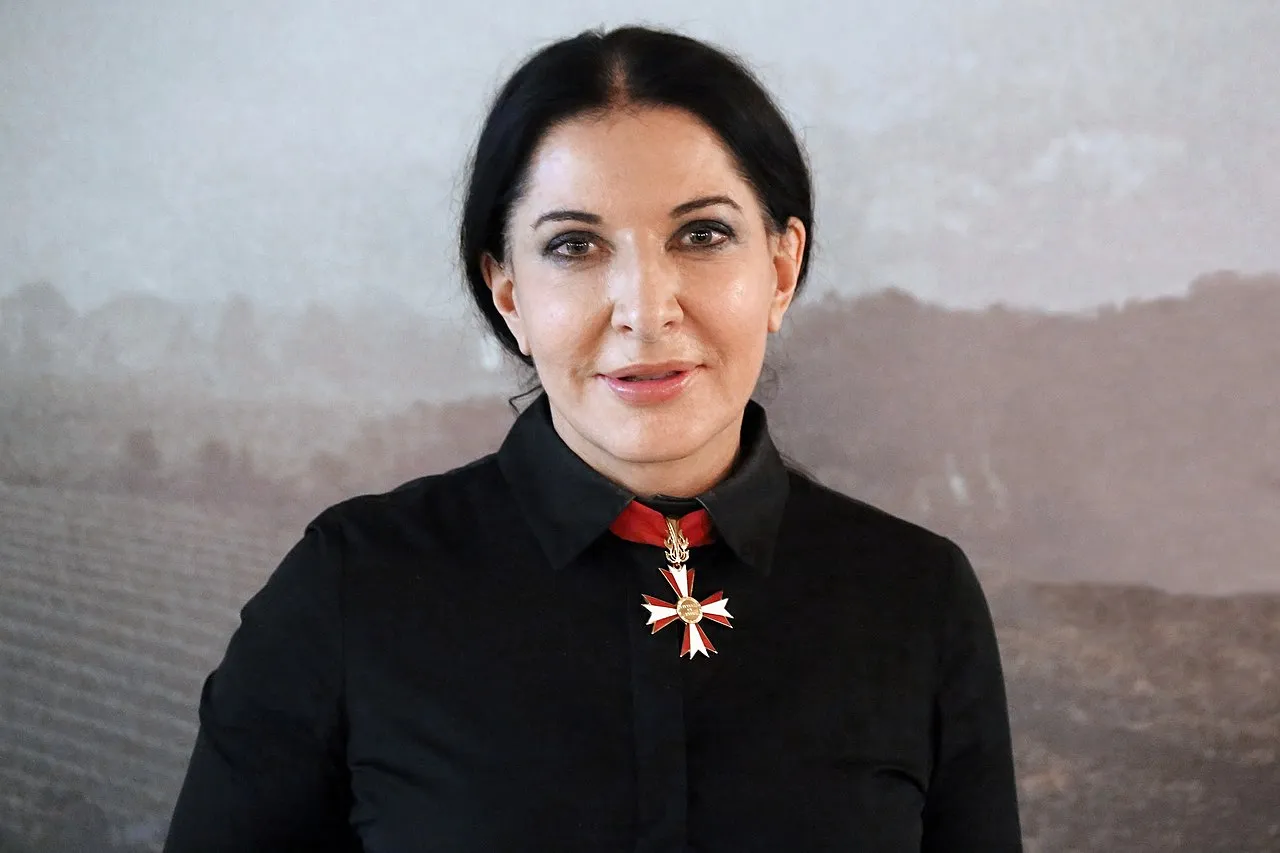 Marina Abramović speaking at a film screening, the renowned performance artist known for her endurance-based works